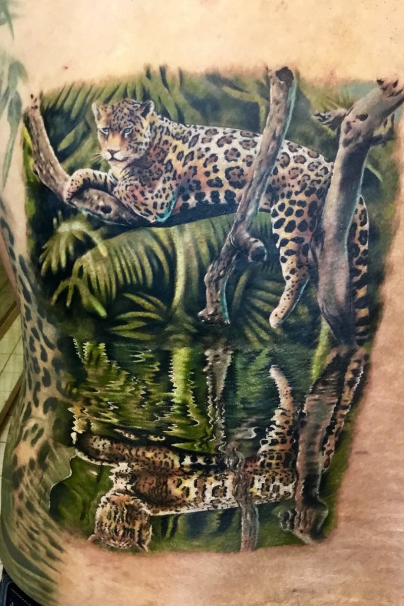 Tatuaje de Jaguar en la jungla reflejandose en el agua